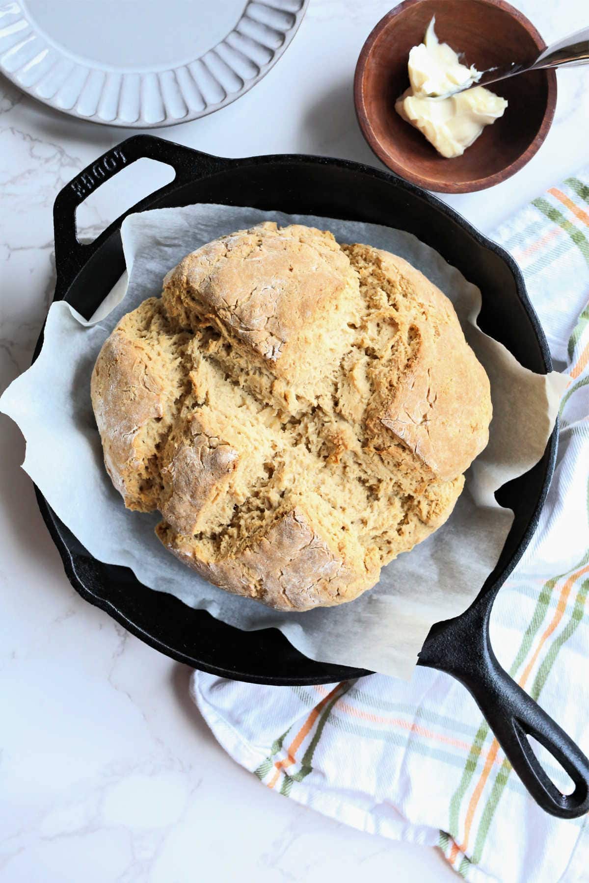 Overview of Irish Soda Bread in an Iron Skillet with a Hand Towel