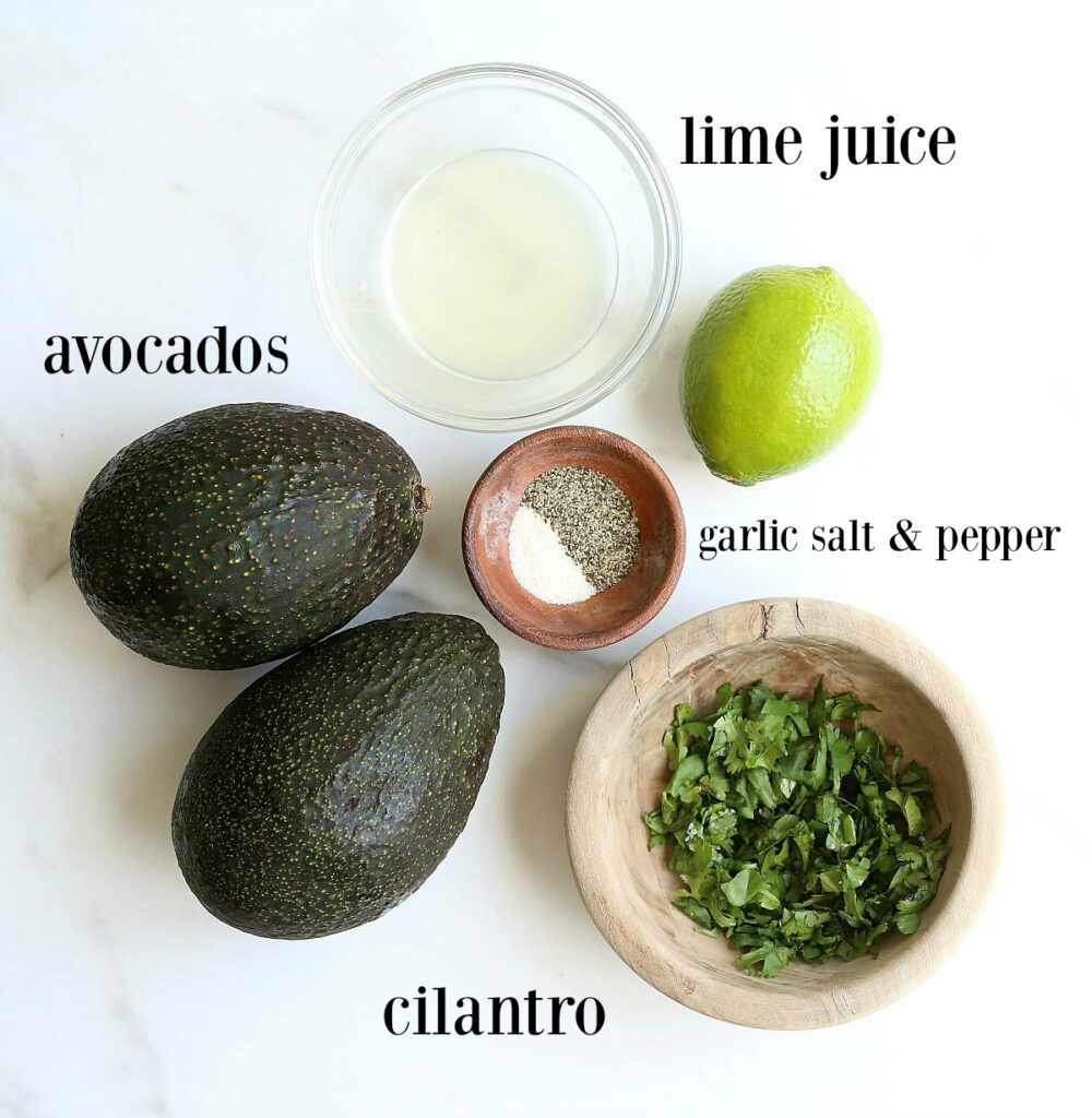 Avocado Fruit, Lime Juice, Salt, Pepper, Cilantro on a Table.