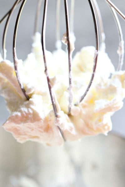 Keto sugar-free whipped cream on an an electric mixer whisk.