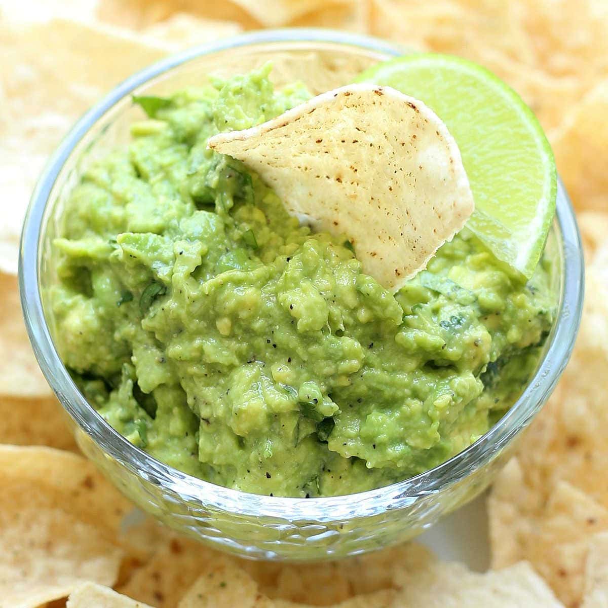 Creamy Homemade Guacamole in a Salsa Dish with Chips.