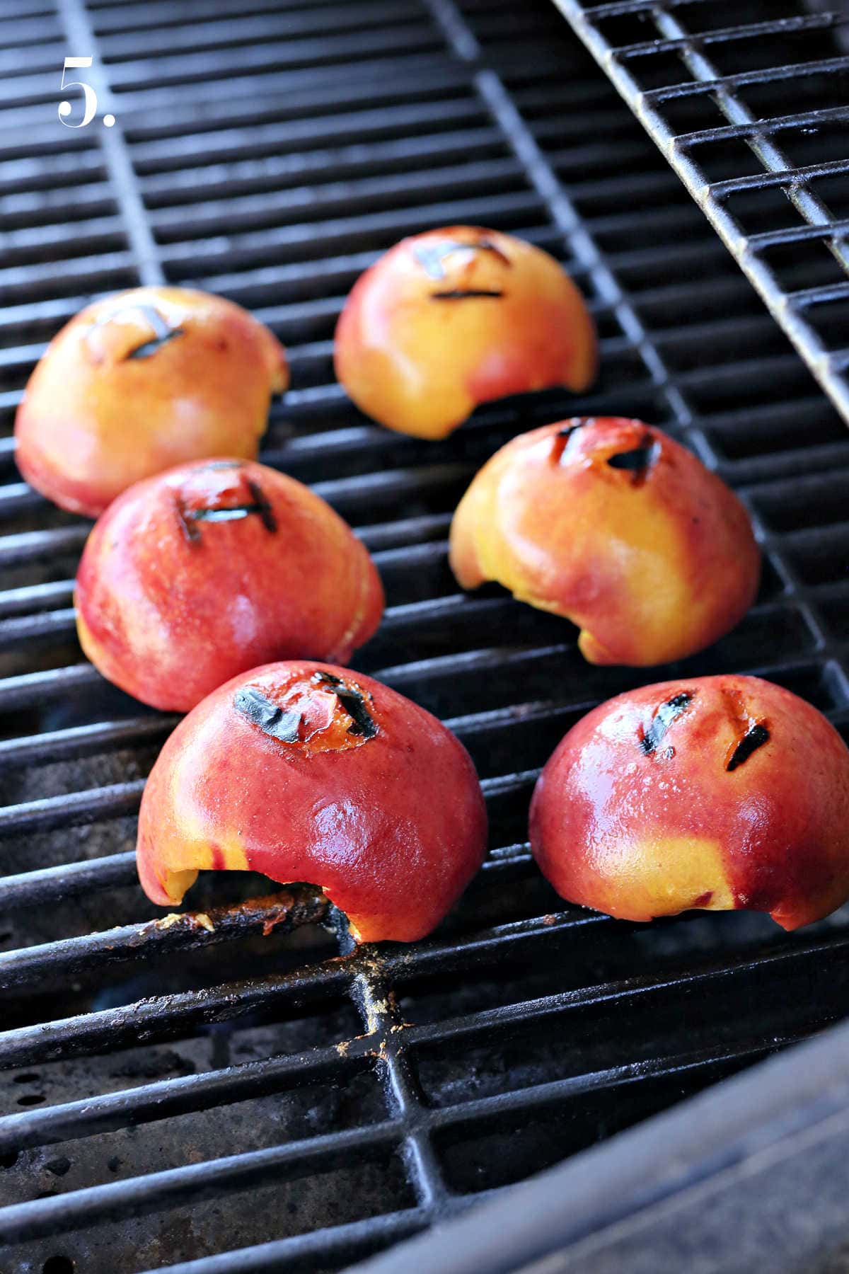 Peach fruit cut in half on the grill.