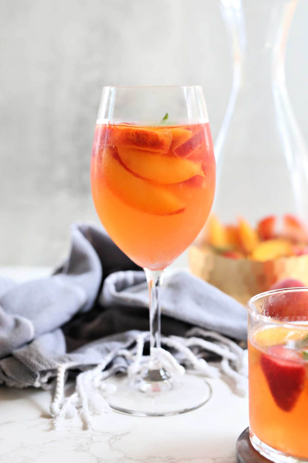 White peach sangria in a wine glass.
