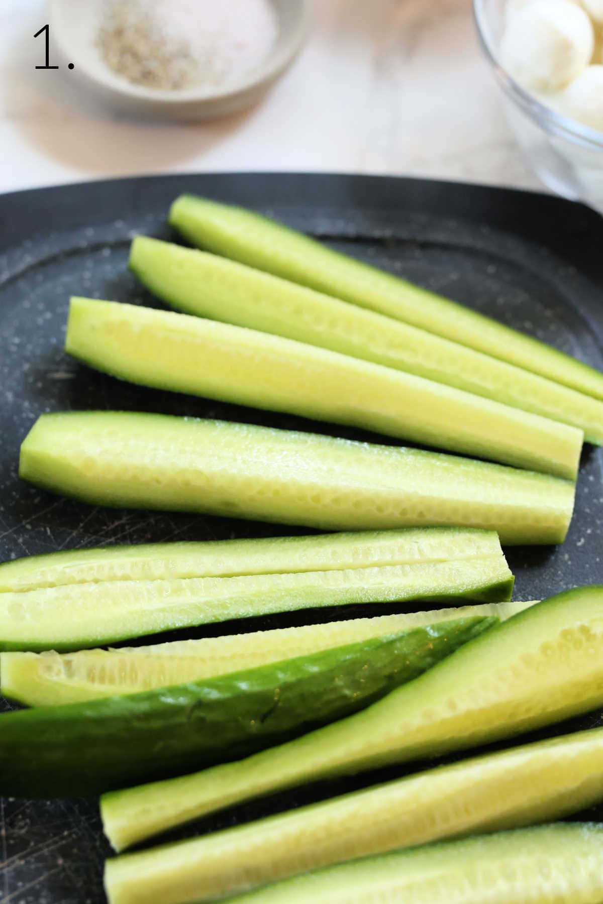 Sliced Persian cucumbers on a cutting board.