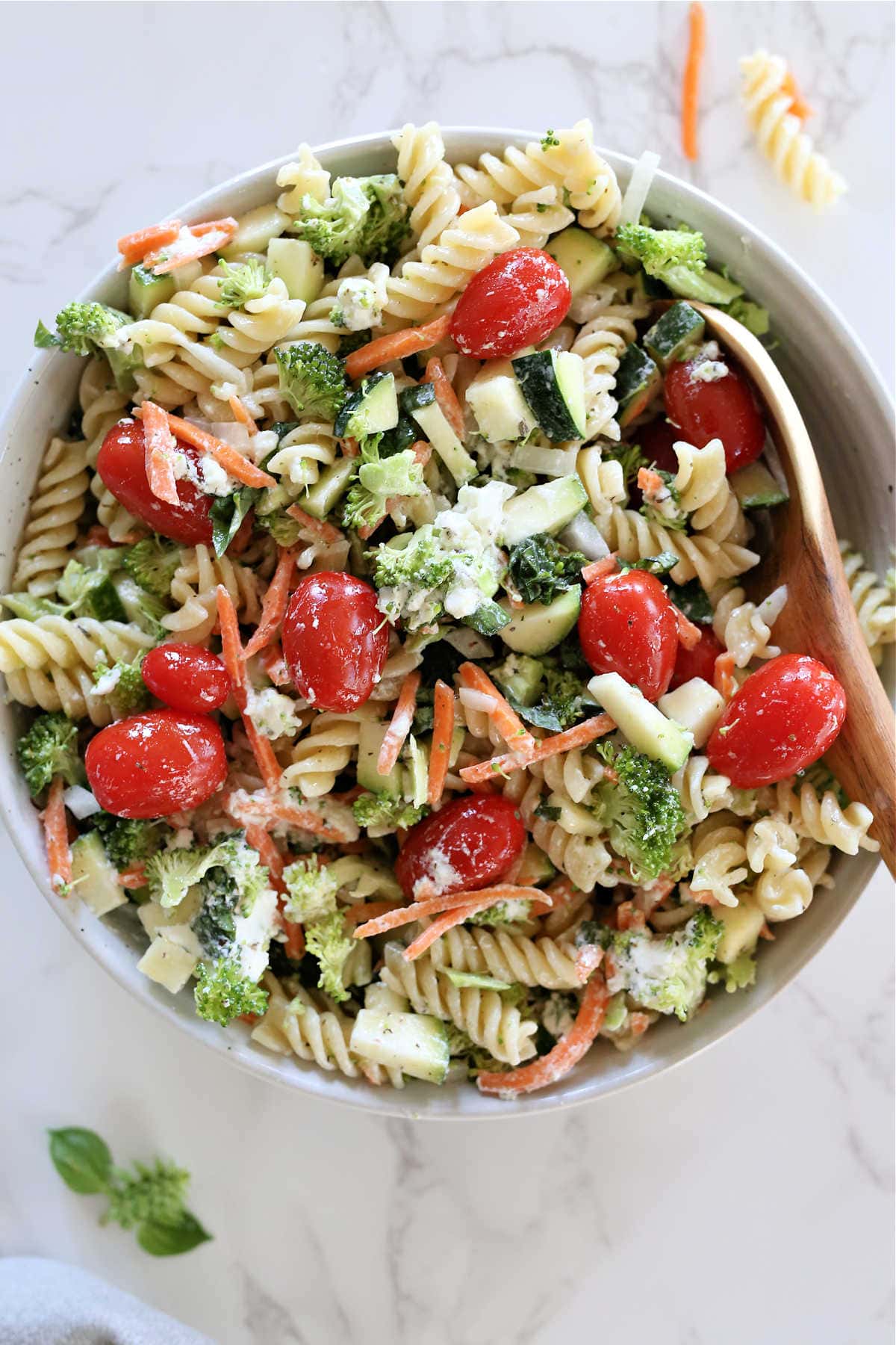 Mixed cold pasta salad with gluten-free noodles, fresh vegetables, and goat cheese.