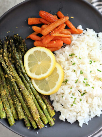 Roasted carrots, asparagus, and rice on a dish.