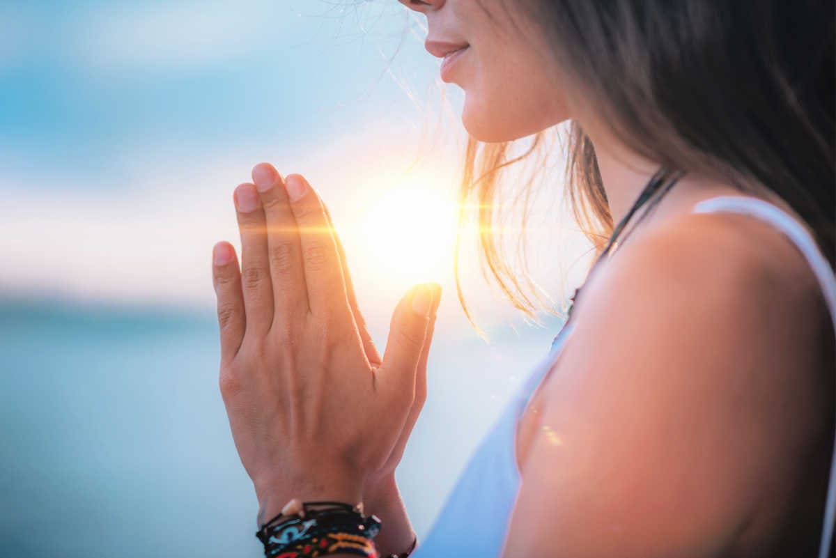 Woman meditating with hands in prayer position.