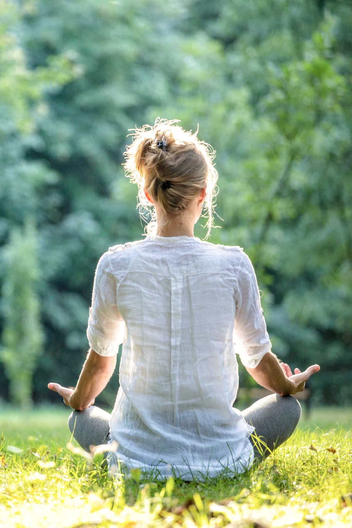 Christian woman meditating outdoors.