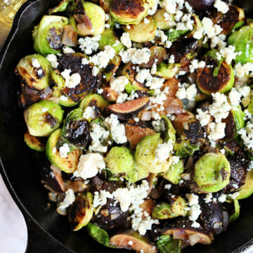 Brussels sprouts fried in a cast iron skillet with fig and blue cheese crumble.