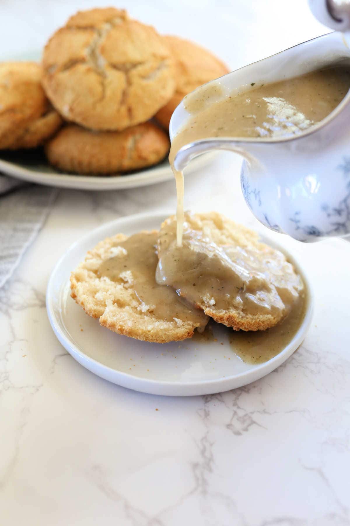 Pouring paleo gravy on dairy-free biscuits.