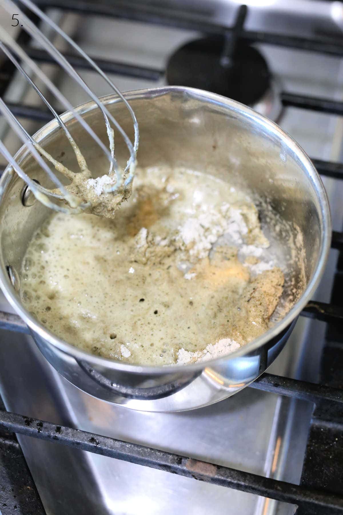 Mixing gravy mix with dairy-free butter on the stove.