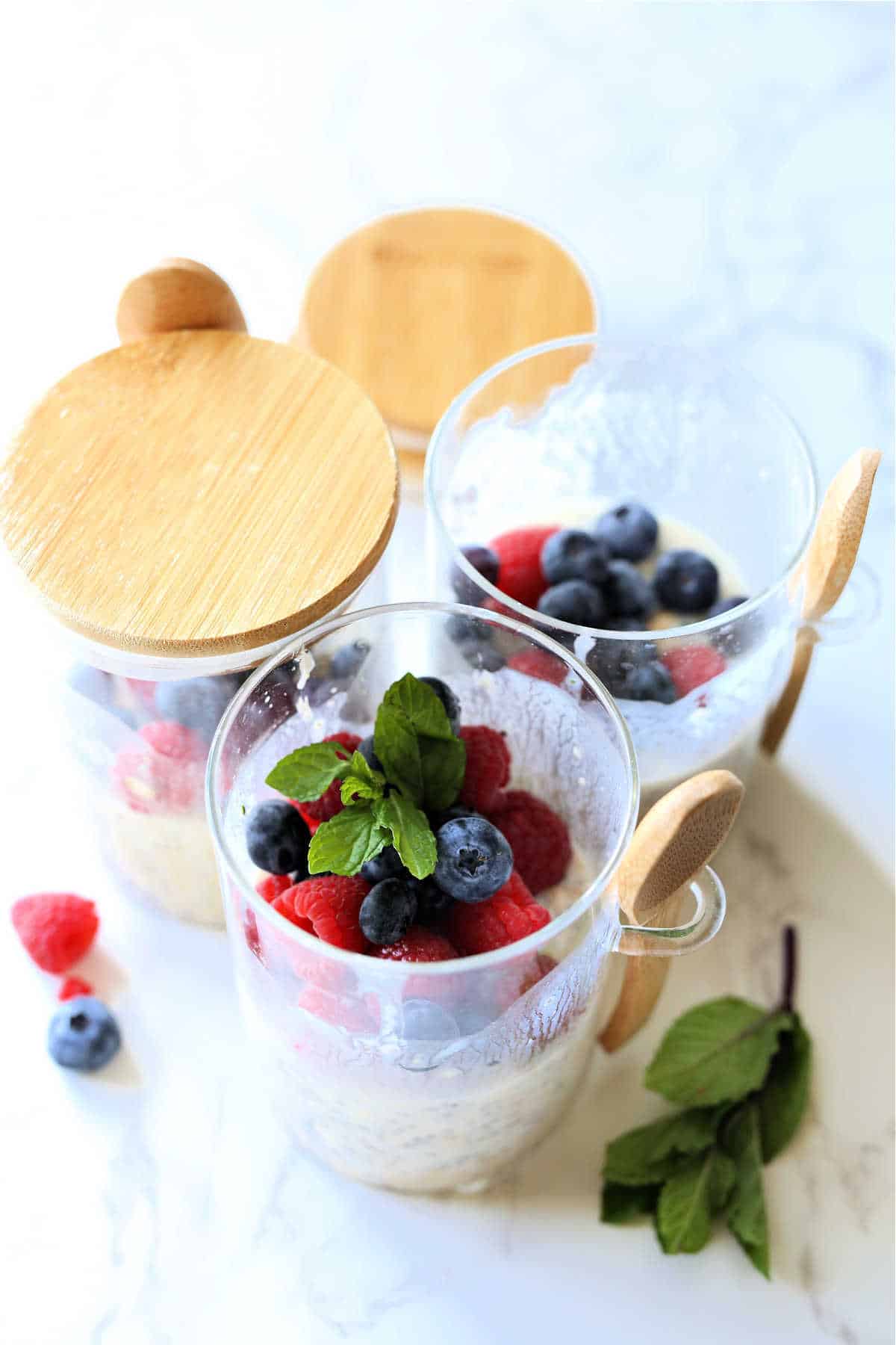 Overnight oats with protein powder and berries in jars.