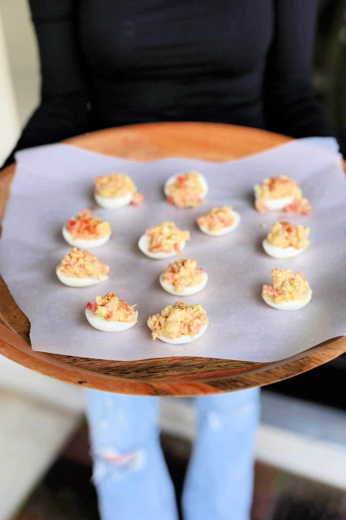 Deviled eggs with shrimp stuffed in a hard boiled egg on a serving wood tray.
