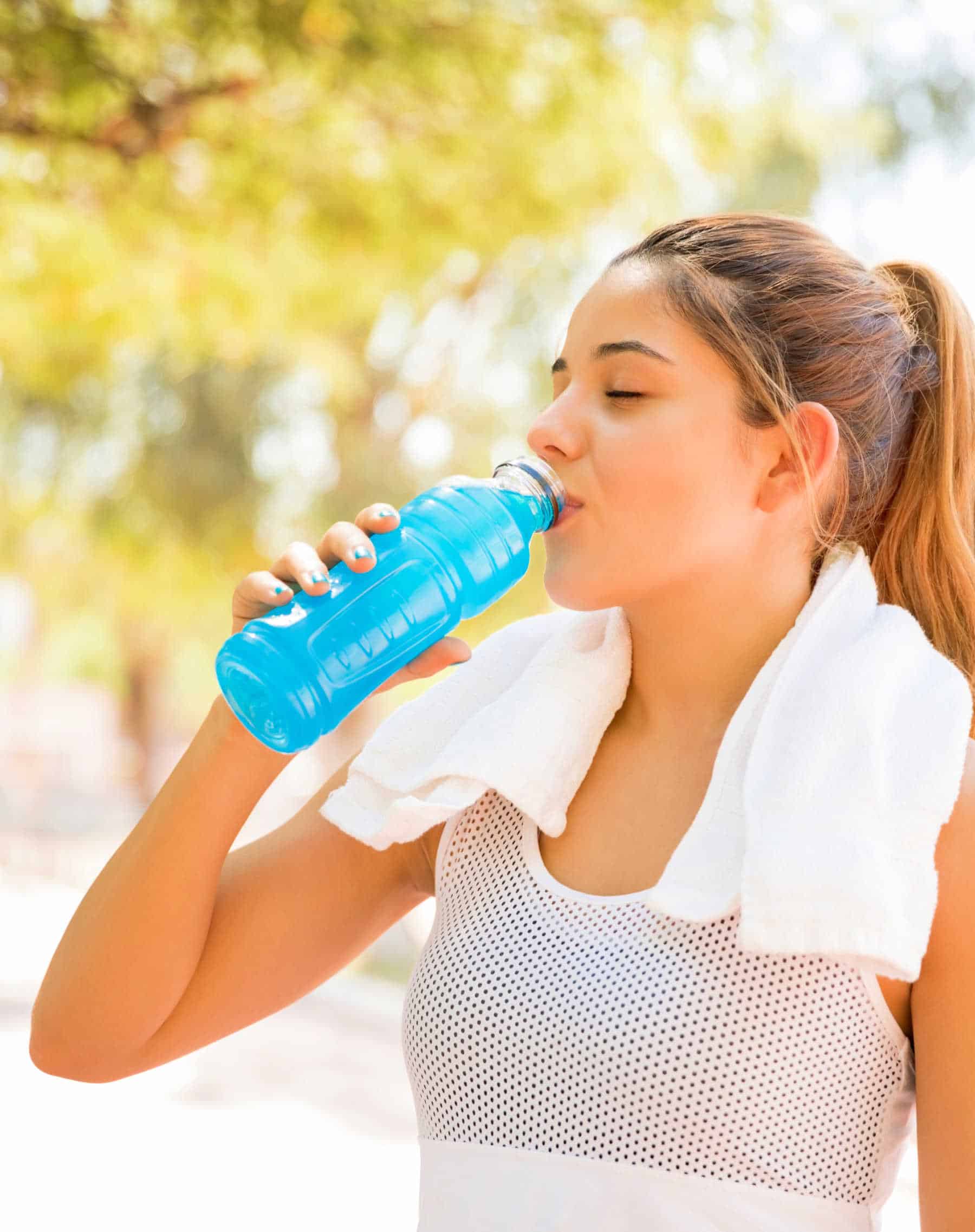 Woman drinking sports drink for hydration, but is it good for you?
