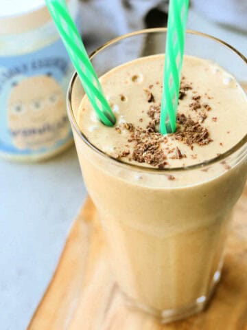 Peanut butter smoothie recipe for kids in a glass with two straws.
