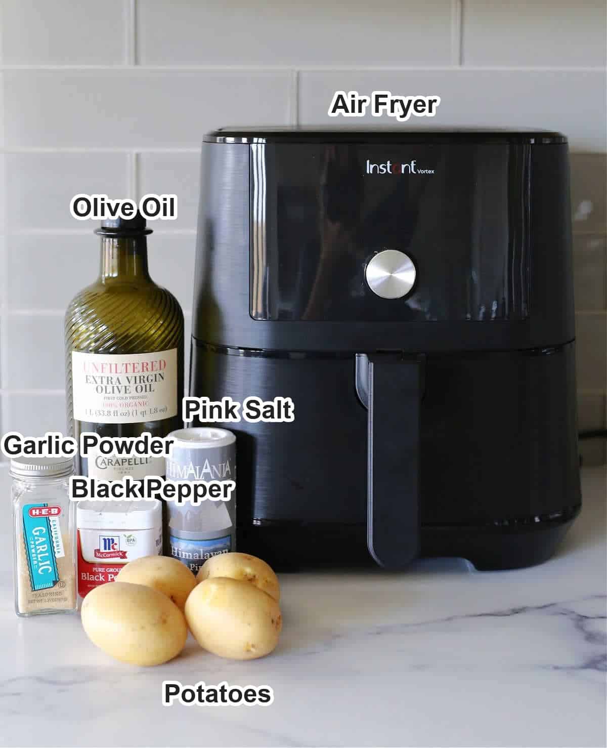Labeled ingredients for air fryer potato wedges: potatoes, olive oil, pink salt, black pepper, garlic powder and an Instant Vortex air fryer.