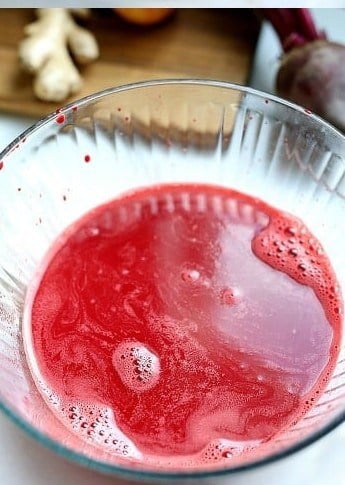 Strained detox beet juice in a bowl ready to pour.