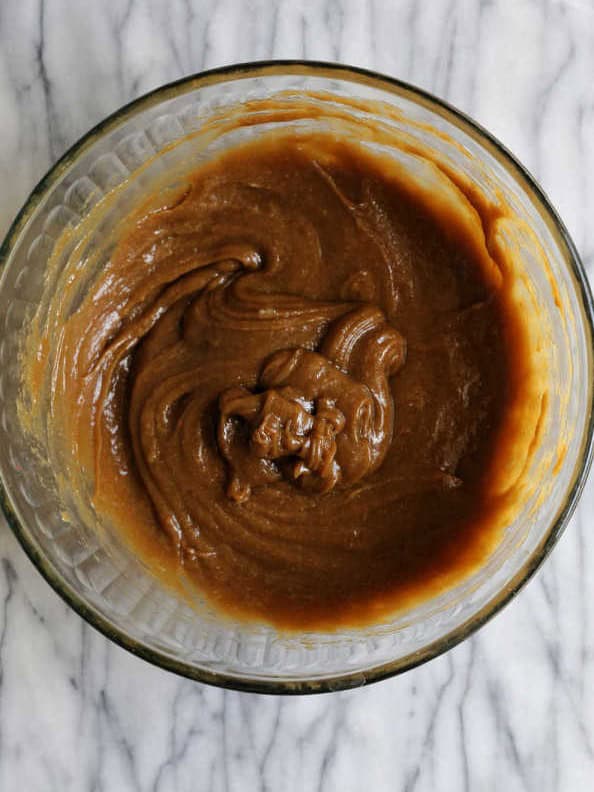 Sunflower seed butter, maple syrup, egg and vanilla creamed together in a glass mixing bowl.