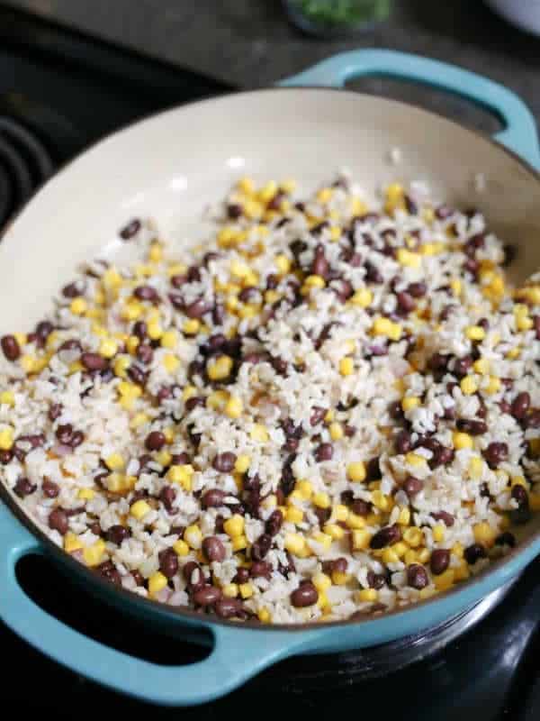 Brown rice, black beans and corn taco salad filling warming in a pan.